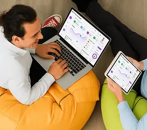 Two people collaborating on laptops and tablets